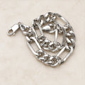 Polished alternating elongated rectangular links and shorter rounded curb links, lobster clasp. On an ivory background