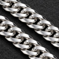 Polished flat curb-link chain with lobster clasp. Macro view of visible bracelet details