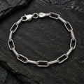 Alternating open and textured elongated links bracelet on a charcoal background