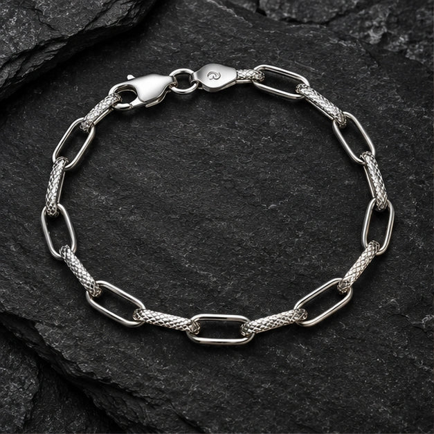 Alternating open and textured elongated links bracelet on a charcoal background