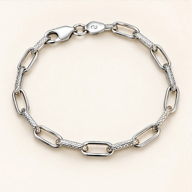 Alternating open and textured elongated links bracelet on an ivory background
