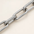 Alternating open and textured elongated links bracelet in a close-up of visible links