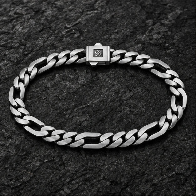 Flat alternating curb and elongated link bracelet on a charcoal background