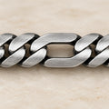 Flat alternating curb and elongated link bracelet in a close-up of visible links
